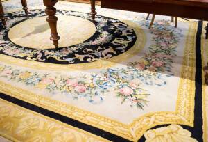 RUG: Louis XVI style gold, black floral rug (margin trimmed). 453 x 300cm.