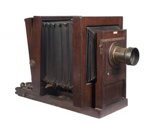 A late 19th century cabinet view size (8" x 6") timber studio camera. The camera with side-hinged ground glass viewing screen that swings out for insertion of plateholder and equipped with a Dallmeyer 3B brass lens SN 38592. The bellows in need of attenti