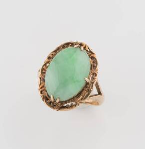 A jade ring, the cabochon jade in a scrolled setting. 14ct yellow gold. Size I1/2. 