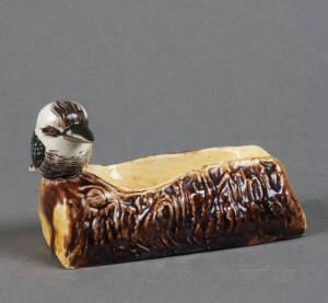 GRACE SECCOMBE: Kookaburra pipe stand glazed in yellow & brown. Remains of original paper label. 7 x 12cm. Good condition