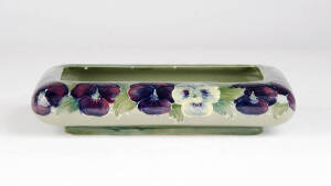 MOORCROFT: Rare & early pansy patterned bowl on celedon green ground, early 20th century. Stamped "Moorcroft Burslem England" with green signature. 21 x 13 x 4.5cm.