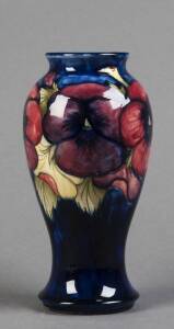 MOORCROFT: Pansy patterned pottery vase on blue ground c1930s. Stamped "moorcroft made in England" with underglaze signature in green. 23cm. VG condition