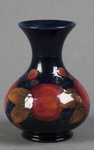 MOORCROFT: Pomegranate patterned onion shaped vase with flared rim. Blue glazed ground