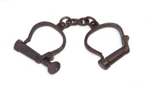 A pair of manacles with key, stamped "British Made", 19th Century.