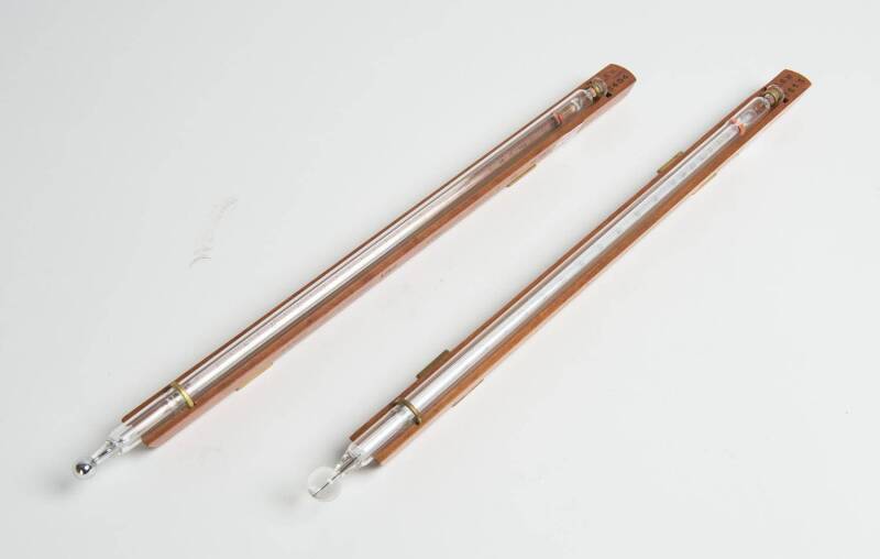 Two standard recording thermometers by Dobbie Bros. Melbourne both in Fahrenheit. One records the minimum the other records the maximum temperature. Both mounted on timber, c1971. 38cm each