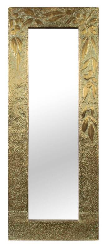 An Australian gum leaf embossed brass framed mirror, in the arts and crafts style. 94cm high, 36cm wide