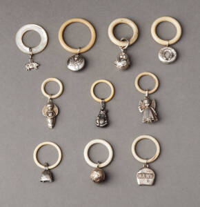 BABY RATTLES: Group of 10 small silver rattles on rings. Angels, bells horseshoes, cat etc.