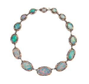 A Rhoda Wager style opal suite, circa 1920's, comprising necklace, bracelet and earrings, set with opal doublets of good colour in foliate style mount with gum leaf motifs. Signed Curio Shop, 76 (Castlereagh) St. Rose gold and silver. 