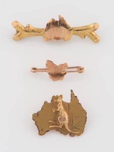 Three gold brooches, one a map of Tasmania, one a kangaroo and map of Australia, the other a map of Australia on a branch, makers include Johnson and Simonsen, Willis and Sons, Melbourne, yellow and rose gold. Weight 4.42 grams.