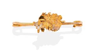 A gold nugget brooch, the gold nugget on a safety pin style bar. Yellow gold. Weight 4.29 grams. Length 3.7mm.