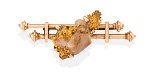 A gold nugget brooch, circa 1900, the double bar brooch set with a gold and quartz nugget. 15ct yellow gold. Weight 14.39 grams. Length 6.3cm. Applied three part bar mark with obscured maker's mark. 