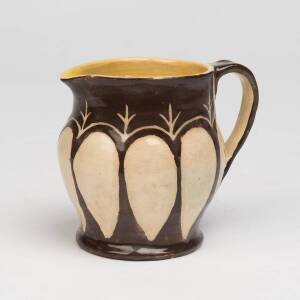 Marguerite Mahood (1901-1989) A wheel thrown glazed earthenware jug decorated with leaf shaped cream panels