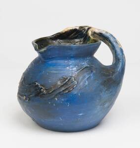 Philippa James (1893-1967) A blue glazed earthenware jug decorated with a windswept tree branch handle