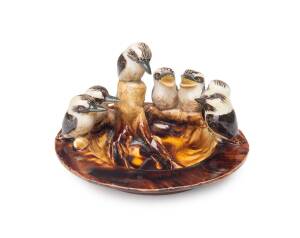 Grace Seccombe (1880-1956) "Seven Little Australians" A wheel-thrown, hand-finished earthenware dish with a row of kookaburras on a tree stump