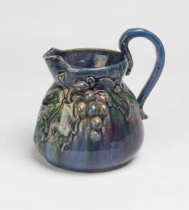 Alison Davidson (active 1933) A blue glazed earthenware jug with applied grapes and leaves