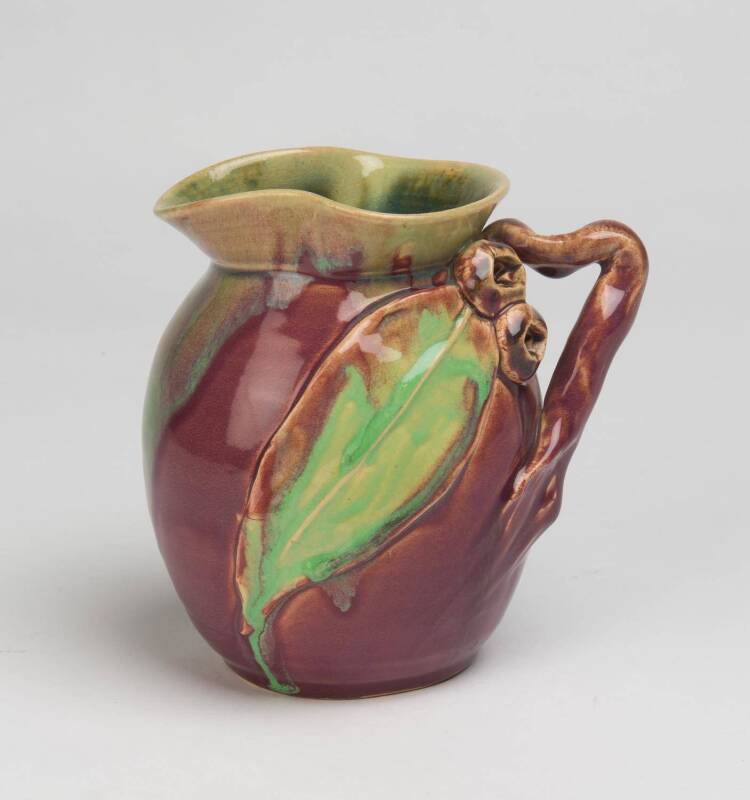 Remued Pottery A pink and green glazed earthenware jug with applied gumnuts and gum leaves