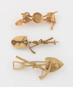 Three gold brooches, two South African Miner's brooches with crossed pick and   shovels and gold nuggets, length of each 50mm; to be sold with a 9ct Miner's brooch, Birmingham, 1964, makers mark J.H.W. Length 48mm. Total weight 15.01 grams.Provenance: A p