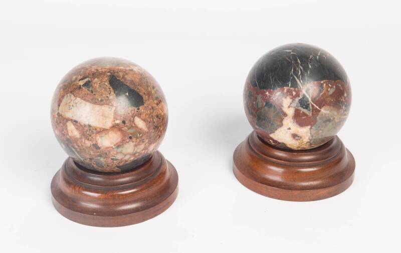 An antique pair of marble spheres on wooden bases (12cm diameter), and a yellow alabaster falcon (36cm high)