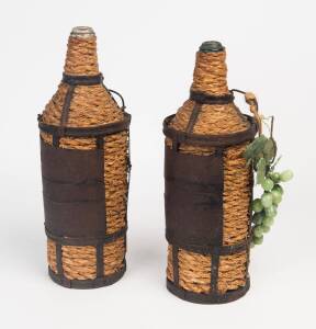 A pair of Italian raffia and metal bound wine bottles together with a small bunch of hard stone grapes
