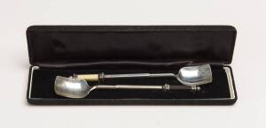 A Modern Australian pair of sterling silver spoons by Ian Ferguson, Melbourne. Shaped handles set with sections of ivory and ebony. 16 cm long, boxed. &diams;