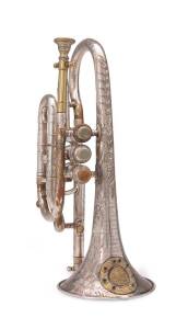A Bb cornet. Beautifully engraved and adorned with rhinestones, made in England inscribed "Patent. Clear Bore. Exhibition Prize Medal Awarded London 1862 & Dublin 1865 to Higham&nbsp;Maker 27 Stangeways, Manchester (37703)". In original fitted wooden case.&nbsp;
