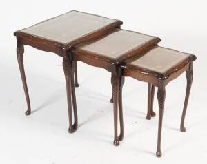 A nest of 3 coffee tables with brown leather inset tops, mid 20th Century. 56cm high, 55cm wide, 41cm deep. 