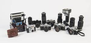 A mixed group of 35mm equipment - cameras and lenses. Cameras include Pentax SPF and K1000, Minolta SRT101b and Ricoh and Cosina SLRs.