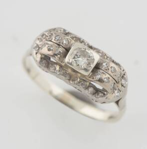 An Art Deco diamond plaque ring, set with single and transition cut diamonds. Gold and palladium. Weight 3.88 grams. Size T.