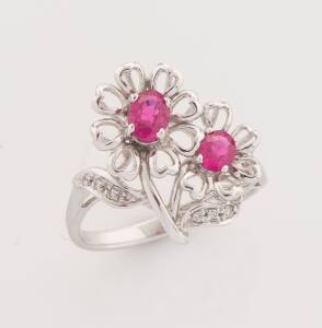 A ruby and diamond flower ring. 18ct white gold. Weight 4.18 grams. Size N ½.