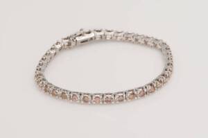 A cognac diamond bracelet, set with thirty-seven round brilliant cut diamonds of total weight 2.93 carats. 18ct white gold. Weight 12.28 grams. Length 16cm.