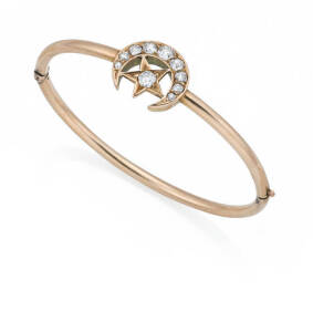 A Victorian diamond star and crescent bangle, circa 1900, estimated total diamond weight 1 carat. Rose gold. Weight 11.76 grams. Inside diameter 58mm.&nbsp;