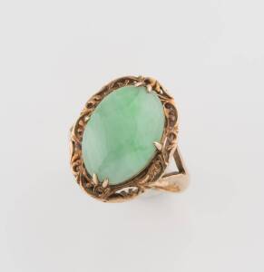 A jade ring, the cabochon jade in a scrolled setting. 14ct yellow gold. Size I1/2.&nbsp;