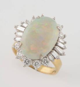 A solid white opal and diamond ballerina ring, the opal measuring 16 x 11mm, in a waved&nbsp;baguette and brilliant cut diamond set surround.&nbsp;14ct yellow gold. Weight 5.87 grams. Size L.
