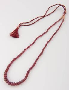 A ruby necklace, graduated, facetted oval beads. Length 44cm
