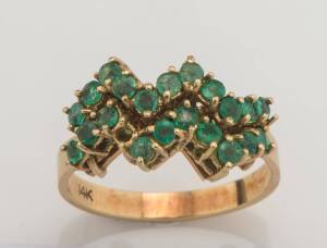 An emerald ring of a double row zigzag design, set with twenty-one round emeralds. 14ct yellow gold.&nbsp;Weight 5.27 grams. Size S&nbsp;&frac12;.&nbsp;&nbsp;One stone deficient.&nbsp;&nbsp;