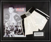  MUHAMMAD ALI, display comprising pair of signed 'Everlast' boxing shorts (signature faded), window mounted with 3-D photo of Muhammad Ali, framed & glazed, overall 105x86cm. With CoA.