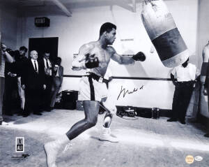 MUHAMMAD ALI, signed photograph of Muhammad Ali with punching bag, size 51x40cm. With 'Online Authentics' No.OA-8090274.