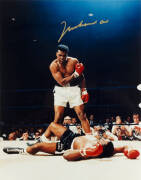 MUHAMMAD ALI, signed colour photograph of Ali standing over Sonny Liston, size 28x35cm. With CoA No.0431.
