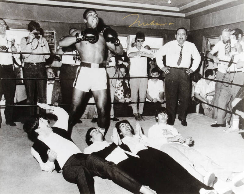 MUHAMMAD ALI & THE BEATLES, photograph of Ali standing over The Beatles, signed "Muhammad Ali", size 51x40cm.