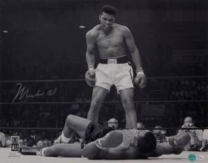 MUHAMMAD ALI, signed b/w photograph of Ali standing over Sonny Liston, size 51x41cm. With 'Online Authentics' No.OA-8090312.