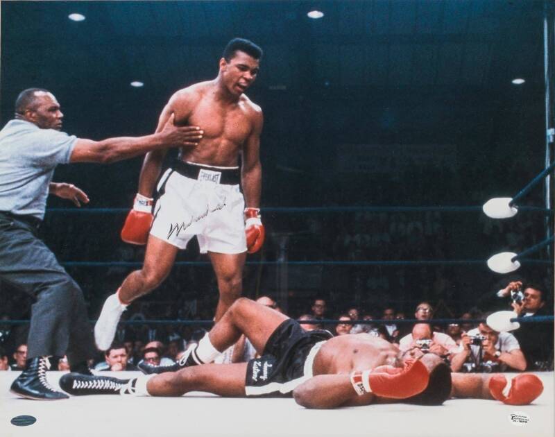 MUHAMMAD ALI, display comprising signed colour photograph of Ali standing over Sonny Liston (signature faded), window mounted, framed & glazed, overall 56x68cm. With CoA.