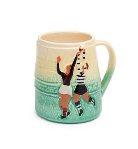 An Australian football pottery mug showing Geelong & Essendon scenes of play, mid 20th Century. 9.5cm.