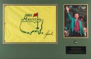 TIGER WOODS, display comprising signature on 2001 Masters flag, window mounted with photograph and caption, framed and glazed, overall 56x83cm.