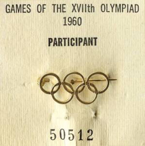 John W.Kelly's IOC Olympic Participant's Badge, Olympic Rings badge, affixed to card "Games of the XVIIth Olympiad, 1960, Participant, 50512", in white presentation wallet with Olympic rings on front & name "John.W.Kelly". Together with Australian flag ba