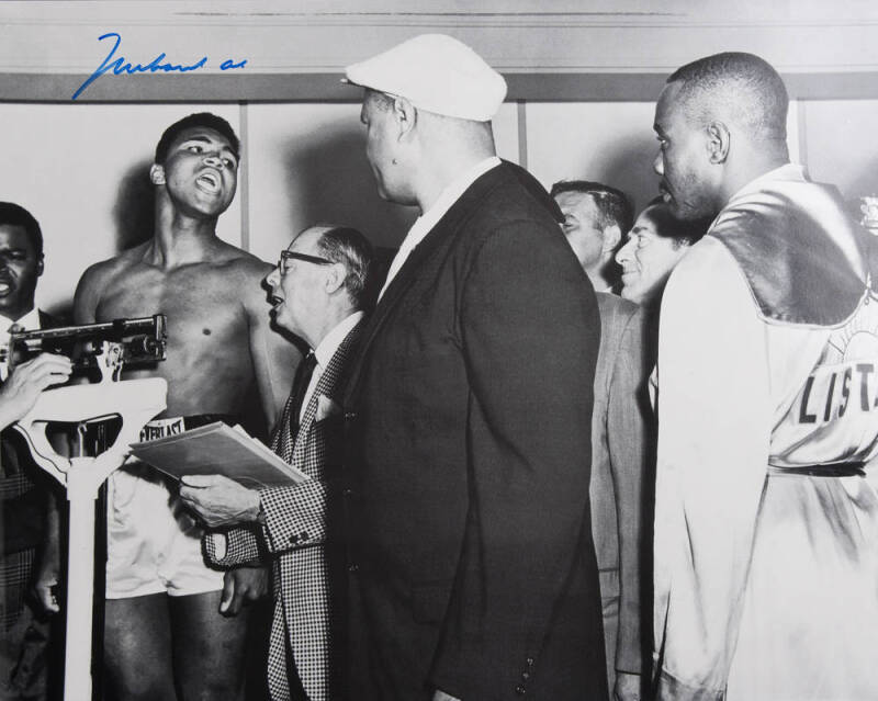 MUHAMMAD ALI, signed b/w photograph of Ali at weigh-in with Sonny Liston, size 51x41cm. With CoA No.0477.