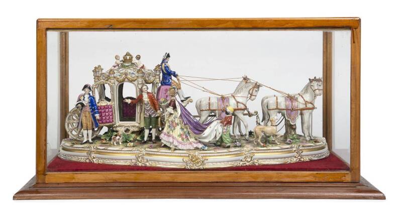 A fine German porcelain Royal carriage and horses, blue crown Naples mark, housed in a purpose built glass and timber display cabinet. 63cm long