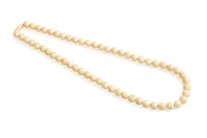 A Chinese ivory bead necklace, early 20th century. 77cm