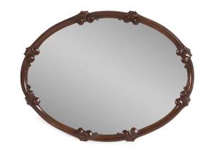 A scroll carved oval mahogany wall mirror. 62cm high, 82cm wide
