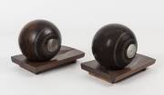 LAWN BOWLS: Pair of Lignum Vitae lawn bowls with silver button engraved "PMBC/ Pair Trophy, F.T.warren, 1901", mounted on wooden stands for use as bookends.