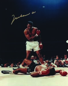 MUHAMMAD ALI, signed colour photograph of Ali standing over Sonny Liston, size 28x35cm. With CoA #0603.